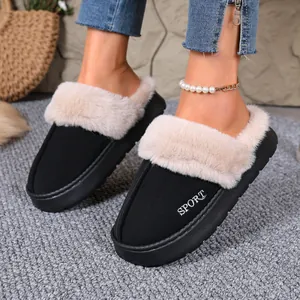 Close-up of stylish black winter slippers featuring a plush beige faux fur collar detail