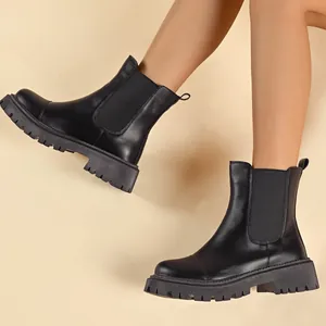 Detailed side view of elegant black round-toe Chelsea boots with thick lug soles