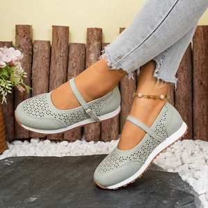 Primer plano de zapatos Mary Jane verde salvia perforados con correa de hebilla