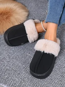 Cozy black winter slippers with plush faux fur lining shown on feet for a warm feel.