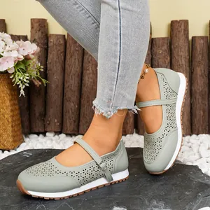 Detalle de zapatos Mary Jane verde claro transpirables con diseño calado con láser.