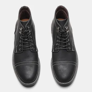 Vista superior detallada de botas de trabajo negras para hombre con costuras blancas