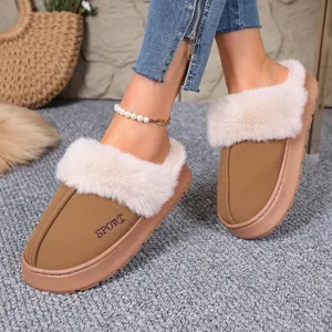 Close-up of tan winter slippers with plush white fur trim and SPORT embroidery.
