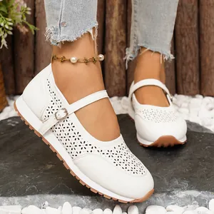 Detalle de zapatos Mary Jane blancos con flores caladas y correa con hebilla