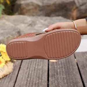 Vista detallada de la suela marrón antideslizante de sandalias de cuña para mujer