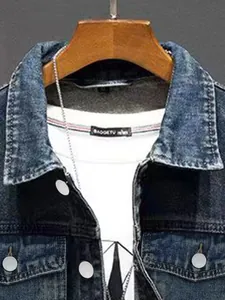 Vue détaillée d'une veste en jean vintage bleue sur un t-shirt blanc classique