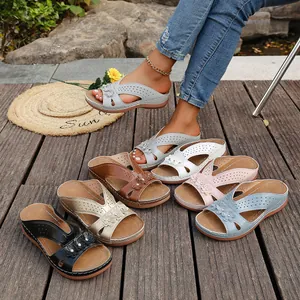 Varios colores de sandalias con cuña para mujer en una terraza de madera al aire libre
