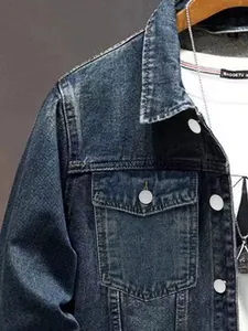 Détail rapproché d'une veste en jean bleu délavé vintage pour homme avec poche