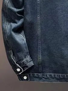 Détail d'une veste en jean bleu rétro pour homme montrant le poignet et les boutons