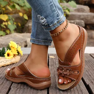 Elegantes sandalias de cuña marrón con detalles florales y perforados para verano