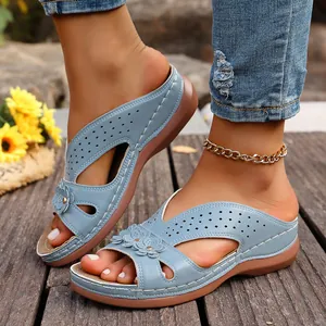 Primer plano de sandalias con cuña azul claro con detalles florales y recortes elegantes