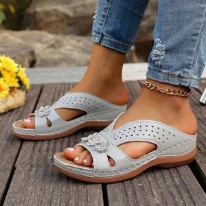 Vista detallada de sandalias con cuña y plataforma en azul claro sobre madera exterior