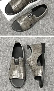 Détail macro de sandales pour hommes gris à motif crocodile gaufré, montrant la texture.