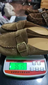Detail shot of a brown suede buckle mule on a scale showing product weight of 361.5g.