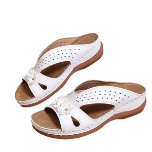 Elegantes sandalias con cuña para mujer con detalles florales y parte superior blanca perforada.
