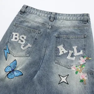 Loose embroidered denim jeans with butterfly and star motifs street style