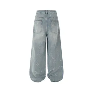Back view of light blue wide-leg denim jeans with paint splatter and rhinestone details.