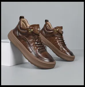 Close-up of premium brown leather high-top sneakers with metal hardware and thick sole.