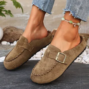 Detail view of brown suede clogs for women featuring a stylish metal buckle strap.