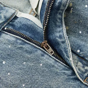 Macro detail of BSJ retro washed denim jeans featuring rhinestones and metal zipper