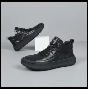 Close-up of premium black leather men's mid-top sneakers with a sleek minimalist design