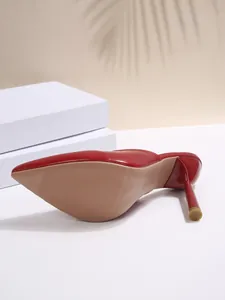 Bottom view of red pointed-toe mules showing non-slip sole and slim high heel detail.