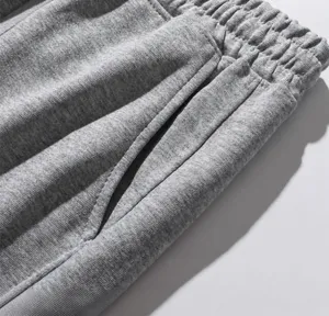 Nahaufnahme graue Jogginghose mit elastischem Bund und seitlicher Eingrifftasche.