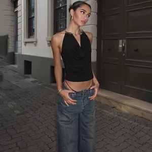 Stylish black sexy metal halter draped neck backless tank top on model in street setting