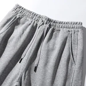 Detailopname van een grijze joggingbroek met elastische tailleband met trekkoord en stof