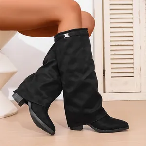 Side detail of black pointed-toe slouch boots with thick heel and metal buckle