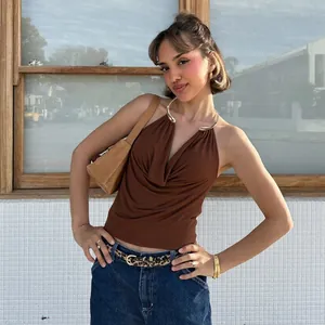 Close-up of a stylish brown halter top featuring a gold metal ring and draped cowl neck.