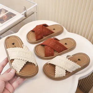 Vista detallada de sandalias para niña con correas cruzadas de punto y bordes pompon
