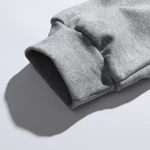 Detailopname van de geribbelde manchet van een grijze joggingbroek met de stoftextuur.