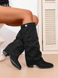 Close-up of black suede slouchy knee-high boots with pointed toe and chunky heel