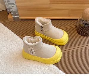 Dettaglio di stivali da neve beige per bambini con fodera in peluche e suole gialle spesse.