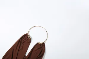 Detailed view of sexy brown halter vest featuring an elegant gold metal ring neckline