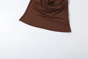 Detail of brown cowl neck top showing soft fabric draping and neat hemline stitching.
