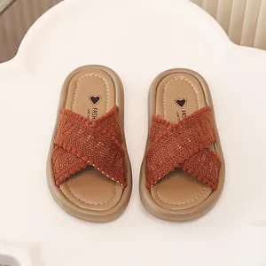 Vista superior detallada de sandalias con tiras cruzadas tejidas para niñas en marrón