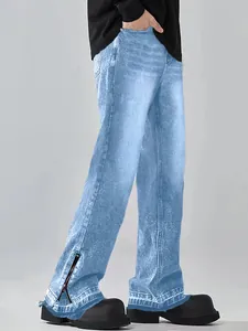 Detailed macro view of men's wide-leg flared jeans featuring a side hem zipper detail