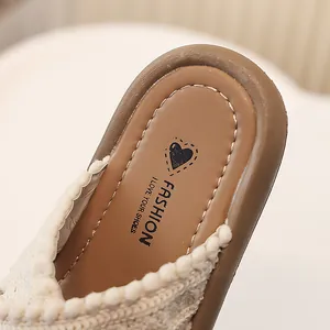 Vista detallada de la plantilla de zapatilla para niña con adorno de pompones blancos