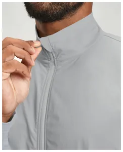 Detailed close-up of the front zipper and standing collar on a grey men's sports jacket.
