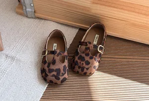 Dettaglio scarpe Mary Jane maculate da bambina in camoscio con fibbia vintage