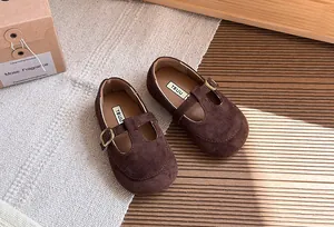 Dettaglio macro di scarpe Mary Jane vintage in pelle scamosciata marrone con fibbia per bambine