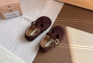 Dettaglio di scarpe Mary Jane stile vintage in camoscio marrone con cinturino a T per bimba