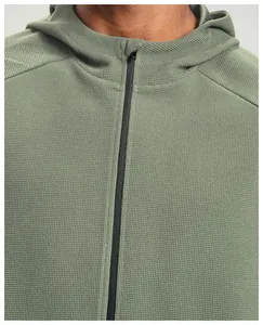 Dettaglio della trama in maglia a nido d'ape verde su giacca sportiva da uomo con cappuccio