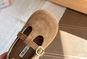 Primo piano di scarpa Mary Jane in camoscio marrone per bambina con cinturino a T e fibbia