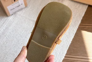 Dettaglio della suola morbida antiscivolo sulle scarpe basse in pelle scamosciata marrone per bambina