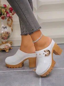 Stylish white closed-toe clogs with thick chunky heels and gold rivet details