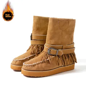 Close-up shot of camel suede snow boots featuring stylish fringe and buckle details.