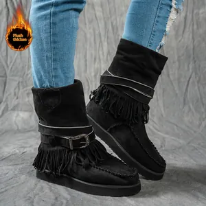 Macro view of black fringed winter boots featuring decorative buckle and plush lining.